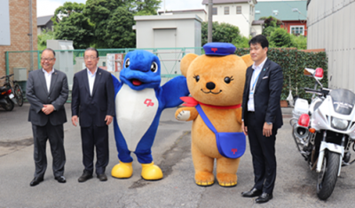 千葉県警察マスコットキャラクター「シーポック」と郵便局マスコットキャラクター「ぽすくま」とともに、佐倉警察署管内の2市1町の首長で記念撮影をする様子。