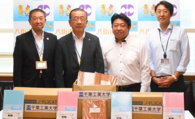 千葉工業大学より寄贈された文房具を受け取っている様子