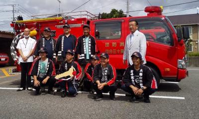 新車両を背にして撮影に応じる北村市長、四木区長、第13分団員。